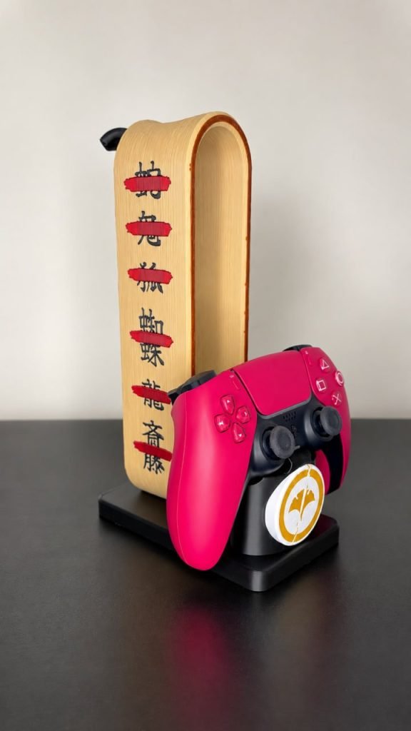 Multicolour 3D-printed headphone and controller stand with kanji details, side view, holding a pink controller