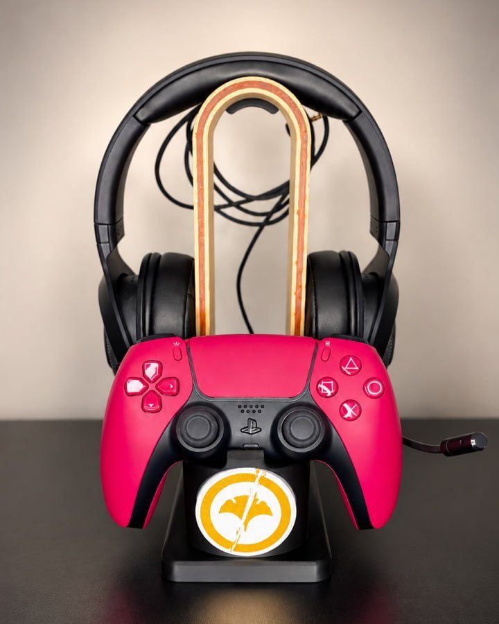 Multicolour 3D-printed headphone and controller stand, front view, holding a pink controller and black headphones