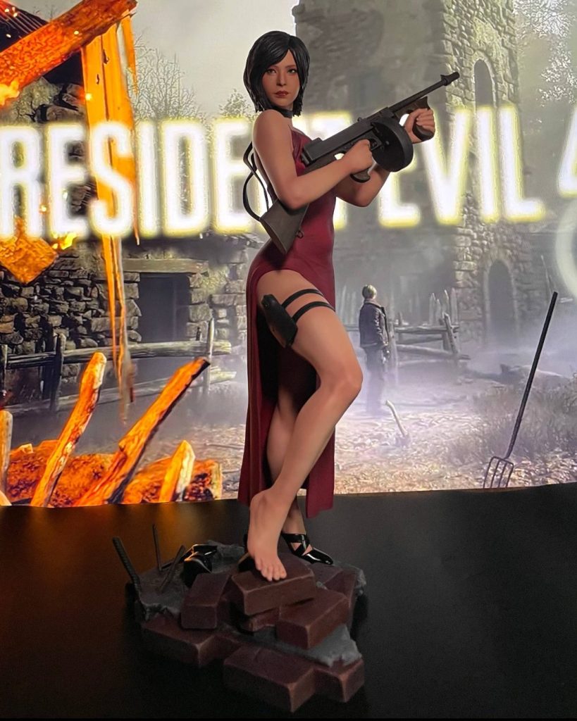 Hand-painted statue inspired by Ada Wong from Resident Evil 4, in a red dress holding a Thompson submachine gun, on a base of bricks